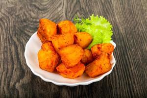 Baked potato on the plate and wooden background photo