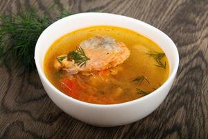 Salmon soup in a bowl on wooden background photo