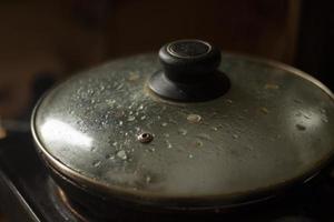 Frying pan with lid in kitchen. Frying pan with swollen glass. Interior of kitchen. photo