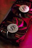 Bitcoin on a graphic card with a Pink neon light on a dark background. photo