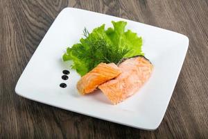 Steamed salmon on the plate and wooden background photo