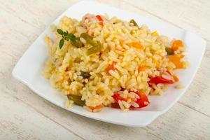 Mexican rice on the plate and wooden background photo