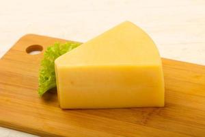 Parmesan cheese on wooden board and wooden background photo