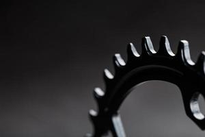 The teeth of the bicycle front star system on a dark background. photo