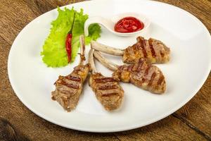 Grilled lamb on the plate and wooden background photo