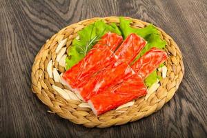 Crab sticks on wooden board and wooden background photo