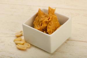 Peanut butter in a bowl on wooden background photo