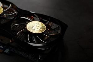 Video card with a gold coin Bitcoin on the cooler close-up. photo