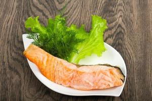 Steamed salmon on the plate and wooden background photo