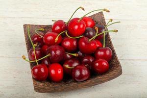 Sweet cherry on the plate and wooden background