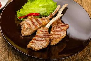 Grilled lamb on the plate and wooden background photo