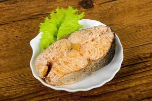 Steamed salmon on the plate and wooden background photo