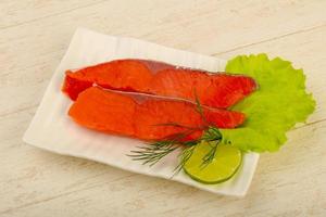 Salted salmon on the plate and wooden background photo