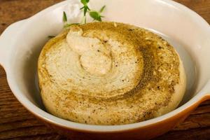 Humus in a bowl on wooden background photo