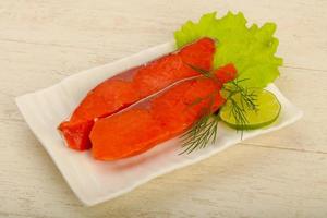 Salted salmon on the plate and wooden background photo