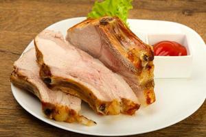 Roasted pork on the plate and wooden background photo