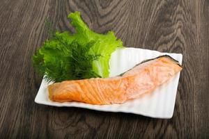 Steamed salmon on the plate and wooden background photo