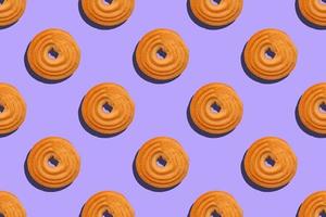 Seamless pattern with round cookies on a violet background photo