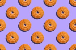 patrón sin costuras con galletas redondas sobre un fondo violeta foto