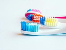 a close up photo of few different color toothbrushes heads
