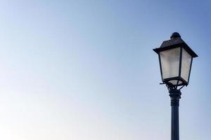 lonely old styled lantern on a clear sky background photo