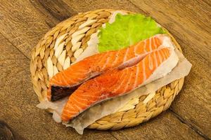 Raw salmon on wooden board and wooden background photo