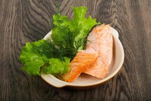 Steamed salmon in a bowl on wooden background photo