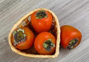 Persimmon on wood photo