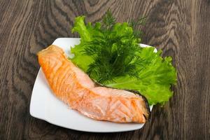 Steamed salmon on the plate and wooden background photo