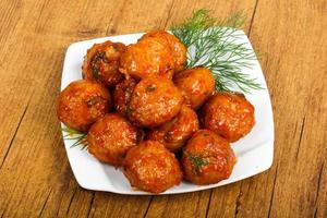 Meat balls on the plate and wooden background photo