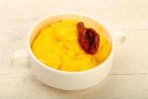 Polenta in a bowl on wooden background photo