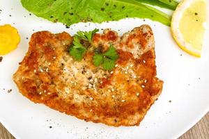 Pork schnitzel on the plate close up view photo