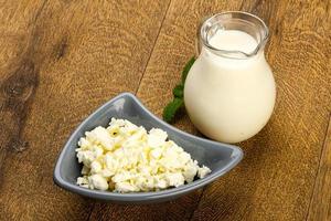 Cottage cheese in a bowl on wooden background photo