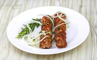 Beef kebab on the plate and wooden background photo