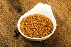 Dijon mustard in a bowl on wooden background photo