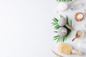 Spa treatment with natural skin care products, herbal bags, towel and wash on white background. Flat lay, copy space. photo