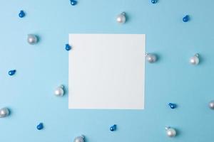 Christmas blue minimal background with mock up greetings card and blue, grey ball. Flat lay, copy space photo