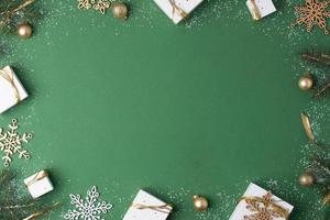 Christmas decorations with packaging gifts on green background. Flat lay, copy space photo