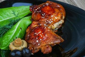 Teriyaki chicken on the plate and wooden background photo