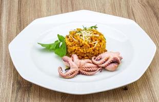 risotto de marisco en el plato y fondo de madera foto