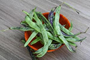 Green beans in a bowl on wooden background photo