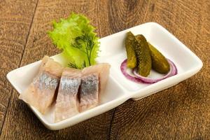 Herring fillet in a bowl on wooden background photo
