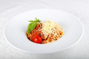 pasta boloñesa en el plato y fondo blanco foto