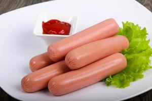 Sausages on the plate and wooden background photo