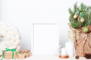 decoración natural de navidad sin desperdicio con romero como árbol de navidad alternativo y marco blanco simulado en la mesa. cerrar, copiar espacio foto