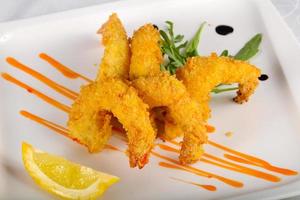 gambas crujientes en el plato y fondo blanco foto