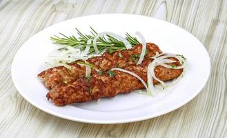 Beef kebab on the plate and wooden background photo