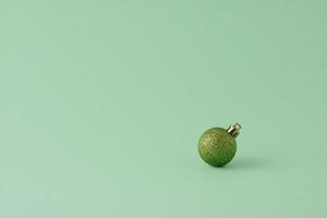 Christmas pastel green minimal background with green ball. Close up, copy space photo