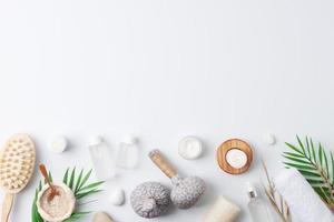 Spa treatment with natural skin care products, herbal bags, towel and wash on white background. Flat lay, copy space. photo