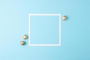 Christmas blue minimal background with white frame and beige ball. Flat lay, copy space photo